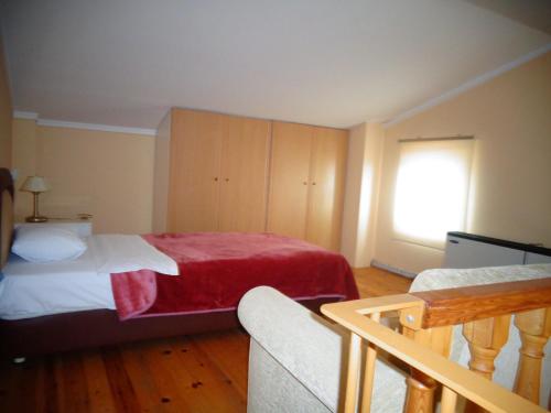 亚历山德鲁波利斯贝尔航空酒店的一间卧室配有一张带红色毯子的床
