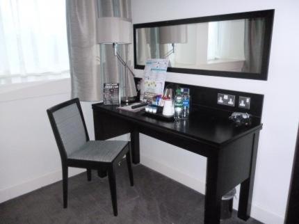 格伦罗西斯The Golden Acorn Wetherspoon的一张桌子,位于酒店的房间,配有椅子和镜子