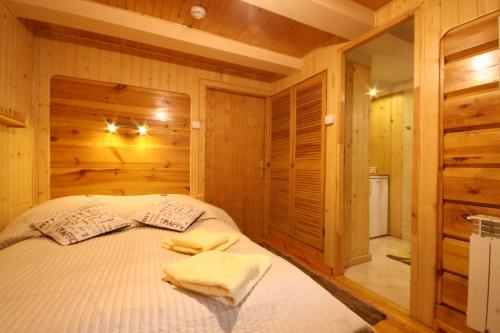 扎科帕内德瓦伊迪斯别墅酒店的一间卧室配有一张带木墙和木地板的床。