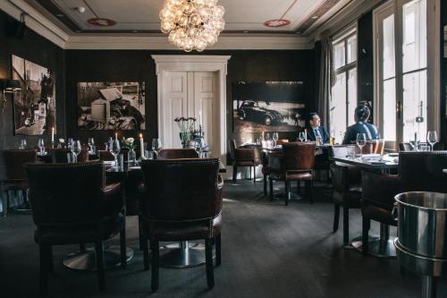 奥斯陆卡米拉斯胡斯酒店的一间带桌椅和吊灯的用餐室