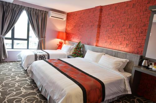 关丹香榭汽车旅馆的红色墙壁的酒店客房内的两张床