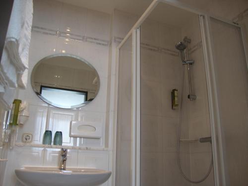 Pockau博尔格施洛申酒店的浴室配有盥洗盆和带镜子的淋浴