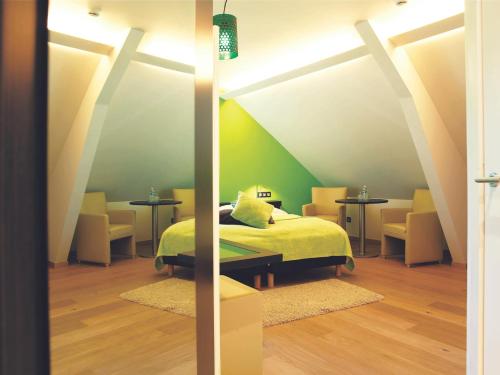 兰登艾欧农皓福酒店的一间卧室配有一张床和两张桌子及椅子