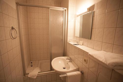奥伯豪森豪斯友尼恩酒店的带淋浴和盥洗盆的白色浴室