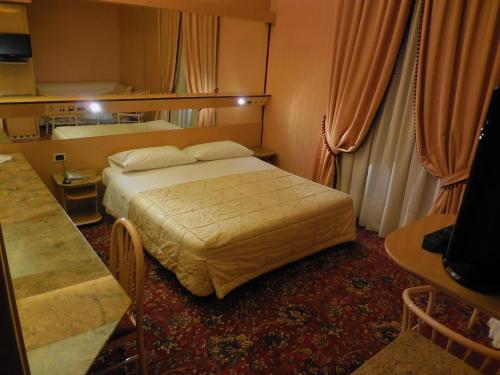 切萨诺博斯科内罗马酒店的酒店客房配有一张床铺和一张桌子。
