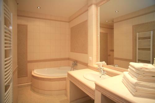 卡罗维发利Slunecni Lazne Apartments的带浴缸、水槽和镜子的浴室