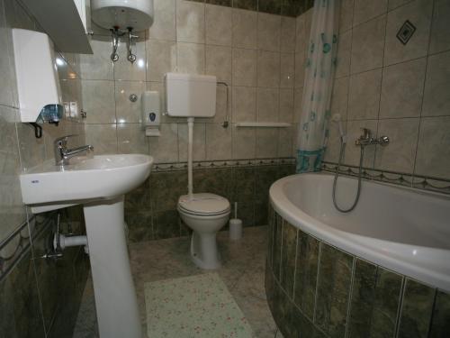 比尔杰巴拉尼亚门公寓的浴室配有盥洗盆、卫生间和浴缸。