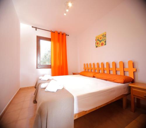 比尼贝卡Binibeca Mar II的一间卧室配有一张带橙色窗帘的大床