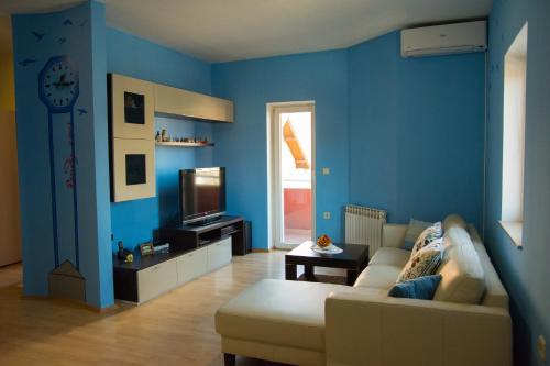 萨格勒布基洛公寓的蓝色的客厅配有沙发和电视