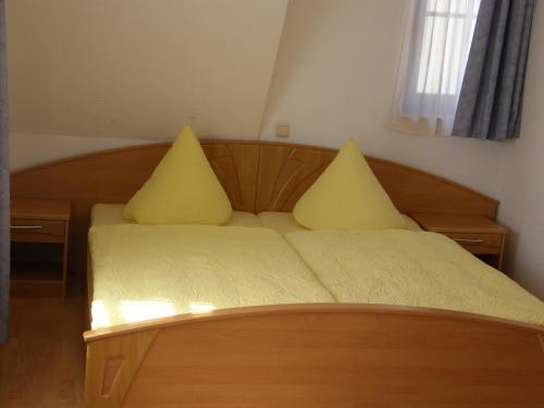 德累斯顿德累斯顿皮耶申膳食公寓酒店的一间卧室配有一张带黄色枕头的床。