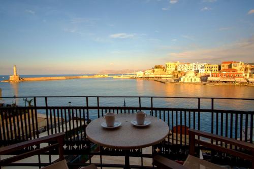 干尼亚艾瑞塔套房公寓的一张桌子,阳台上放着两杯咖啡,可俯瞰水景
