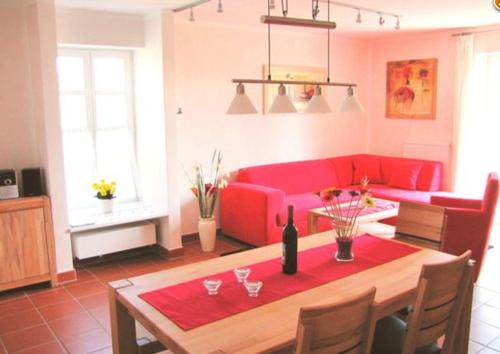 德兰斯克Ferienwohnung Bakenberg auf Rügen (So)的客厅配有桌子和红色沙发