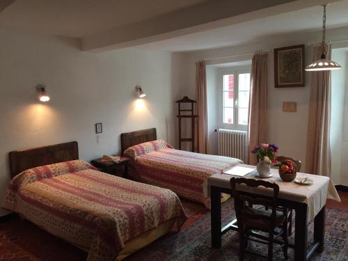 旺斯阿博格领主酒店的酒店客房带两张床、一张桌子和一张桌子。