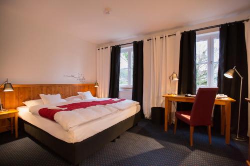 费尔巴赫布克勒酒店的一间卧室配有一张床、一张桌子和一把椅子