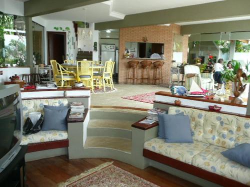 乌巴图巴Casa do Morro - Avenida Uniflora的一间带两张沙发的客厅和一间厨房