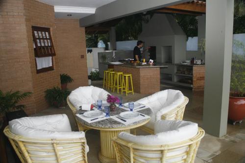 乌巴图巴Casa do Morro - Avenida Uniflora的一个带桌椅的庭院和一间厨房