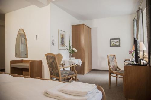 翁纳阿克岑古特霍因酒店的酒店客房带一张床、一张桌子和椅子