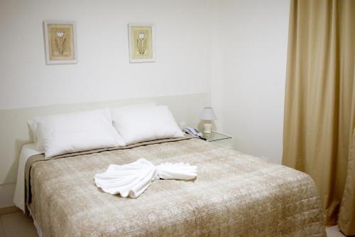 累西腓Pousada Lorde Inglês的一间卧室配有一张床,床上有浴袍