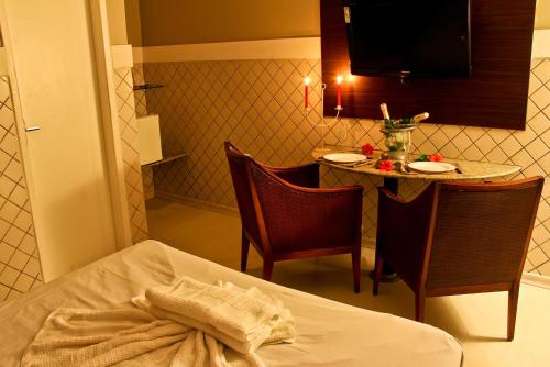 累西腓恩里克·迪亚斯（仅限成人）情趣酒店和汽车旅馆的客房设有桌子、床和桌椅。