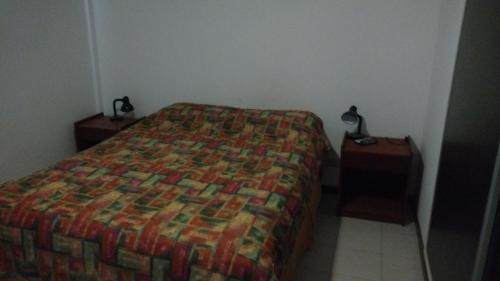 玛德琳港Madryn Duplex的一间卧室配有一张床,还有两个带灯的床头柜
