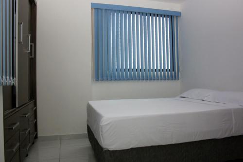 若昂佩索阿绿色公园公寓的卧室配有白色的床和窗户。