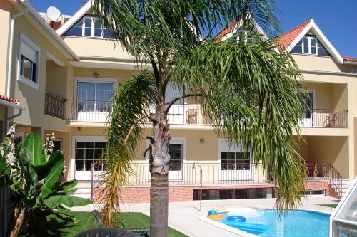 菲盖罗杜什维纽什索拉达芙莱斯乡村酒店的一座棕榈树和游泳池的建筑