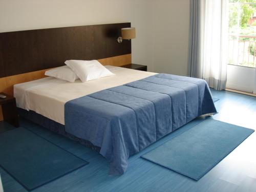 菲盖罗杜什维纽什索拉达芙莱斯乡村酒店的卧室配有一张蓝色地毯。