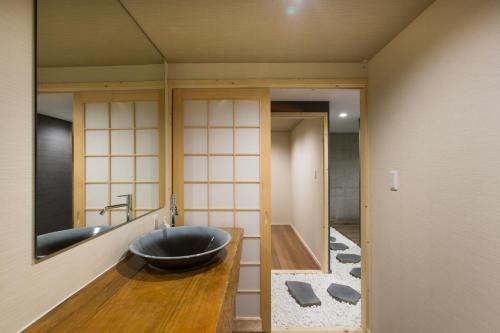 二世古灰岩度假屋的一间带水槽和大镜子的浴室