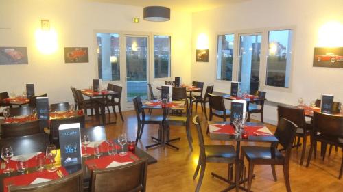 加来Logis Cottage Hôtel的用餐室设有桌椅和窗户。