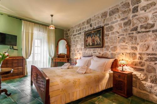 科托尔蒙特克里斯托酒店的一间卧室配有一张石墙床