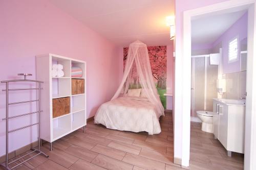拉卡尔洛塔卡洛斯三世露营酒店的一间卧室配有一张带蚊帐的床