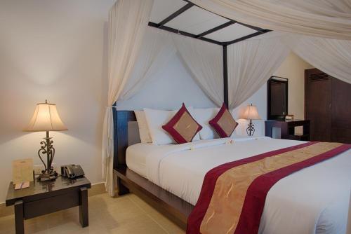 塞米亚克图卡德别墅酒店的一间卧室配有一张带天蓬的大床