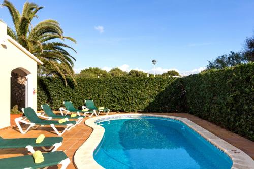卡拉布兰卡Villa Menorca Cleo by Mauter Villas的游泳池周围设有躺椅和椅子