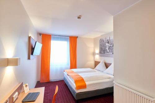门兴格拉德巴赫门兴格拉德巴赫梦想酒店 的配有一张床和一张书桌的酒店客房