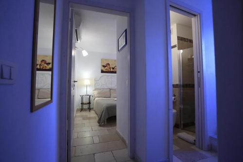 滨海波利尼亚诺La Casetta Nel Vico的蓝色的客房设有1间带1张床和镜子的卧室