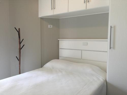 瓜鲁雅Apartamento Vereda Tropical的白色卧室配有一张床和白色橱柜