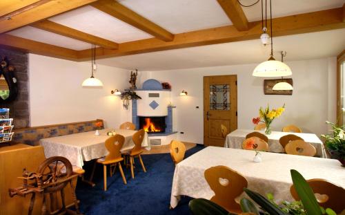 奥蒂塞伊Garni-Hotel Pichler的一间带2张桌子和壁炉的餐厅