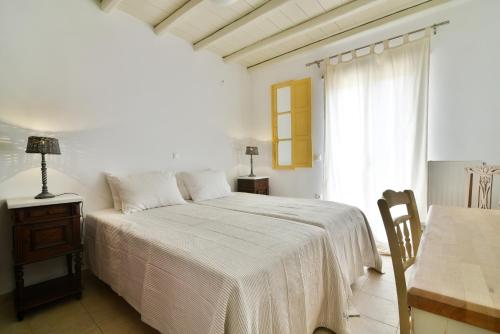 提诺斯阿克罗提拉基别墅的白色的卧室设有床和窗户