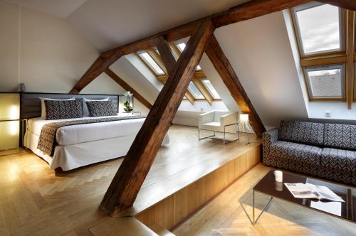 布拉格塔利亚欧洲之星酒店的阁楼卧室配有1张床和1张沙发