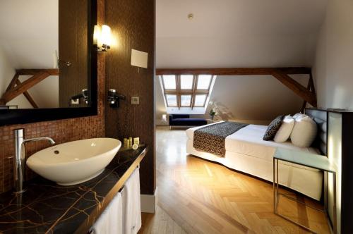 布拉格塔利亚欧洲之星酒店的一间带水槽的浴室和一张位于客房内的床