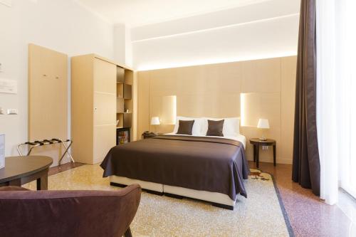 罗马多莫斯特兰乔酒店的卧室配有1张床、1张桌子和1把椅子