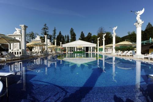 劳耶克特普利采阿佛洛狄特宫酒店的一座带椅子的大型游泳池和一座建筑