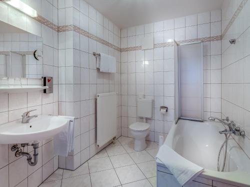 布格施塔加德Hotel Zur Burg GmbH的一间带水槽、浴缸和卫生间的浴室