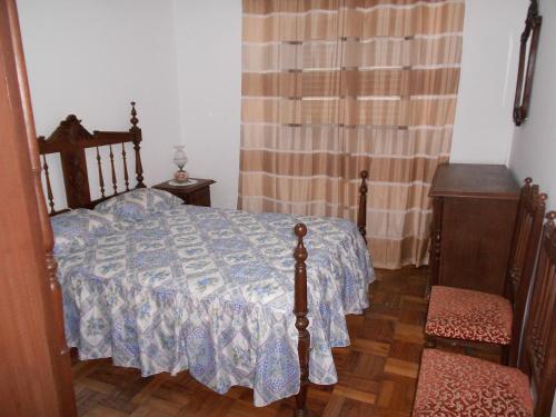 圣托·蒂尔索Santo Tirso Holidays Home的一间卧室配有一张床、两把椅子和一个窗户