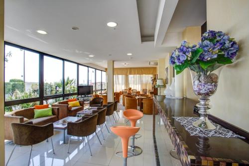 贝拉里亚-伊贾马里纳迪安娜酒店的大堂设有桌椅和花瓶