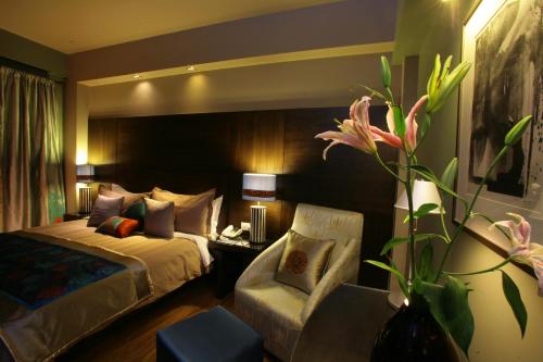 古尔冈古尔冈胡斯塔酒店 的配有一张床和一把椅子的酒店客房