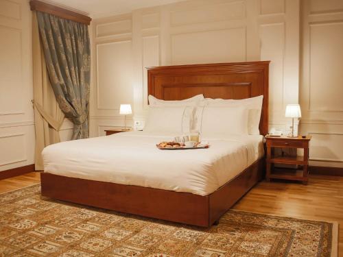地拉那Hotel Opera的一间卧室配有一张床,上面放着一个食物托盘