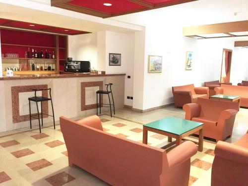 罗迪-加尔加尼科里帕维拉焦酒店的一间设有橙色椅子和酒吧的等候室