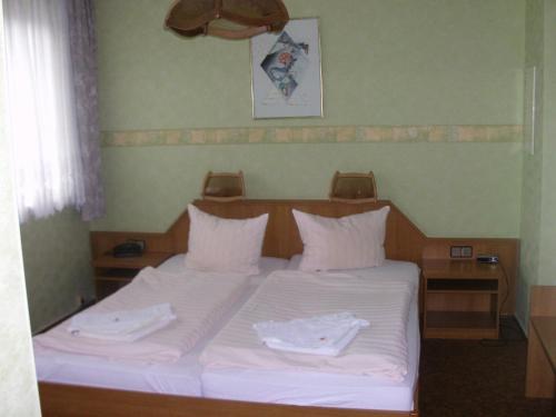 马尔欣马库斯酒店及餐厅的一张带白色床单和白色毛巾的床