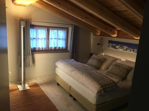瓦托内切4478 山间住宿加早餐山林小屋的卧室配有一张大白色床和窗户